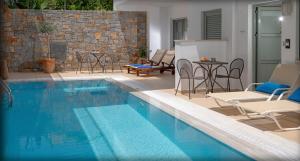 a swimming pool with chairs and a table and a tablektop at Angela Suites Boutique Hotel in Sisi