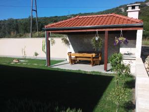 a gazebo with a wooden table in a yard at Apartments Čirjak in Sveti Petar