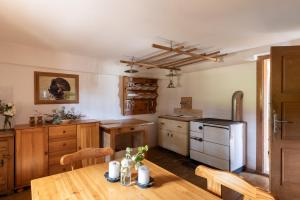 a kitchen with a wooden table and a kitchen with a refrigerator at Ochsenwaldhütte in Teschrepl