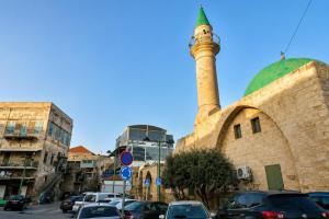 a mosque with a minaret on top of a building at האבן והים - סוויטה מדהימה עם ג'קוזי בעיר העתיקה עכו in Acre