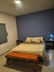 a bedroom with a bed with a blue wall at Finca Las Marías in Cardozos