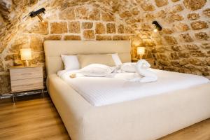 a bedroom with a bed with a swan on it at האבן והים - סוויטה מדהימה עם ג'קוזי בעיר העתיקה עכו in Acre