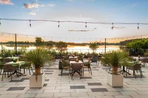 a patio with tables and chairs and a lake at Hotel Duo Spa in Janów Lubelski