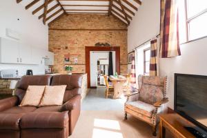 a living room with a couch and a television at Cottage 2 at Scald end cottages in Bedford