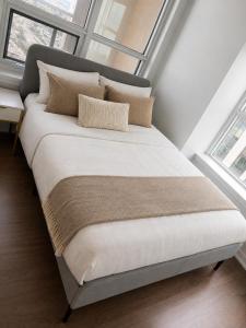 ein großes Bett in einem Zimmer mit Fenstern in der Unterkunft Simply Suites in Vaughan