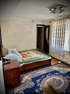 a bedroom with a bed in a room with a rug at Chashma in Ishkashim