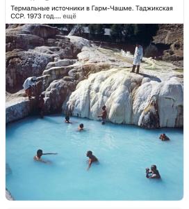 a group of people swimming in a pool of blue water at Chashma in Ishkashim