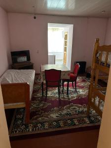 a room with a bed and two chairs and a table at Chashma in Ishkashim