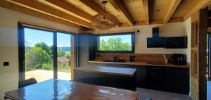 a kitchen with a table and a large window at Le BÔ Chalet - Jacuzzi et Sauna - 3 chambres in Anould