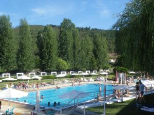 a large swimming pool with people sitting around it at Casa da Piedade in Marvão