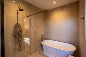 a bathroom with a bath tub and a shower at Tolaini Winery Suites in Castelnuovo Berardenga