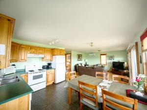 a kitchen and dining room with a table and a kitchen and a living room at Montgomery Cavendish Cottages in New Glasgow
