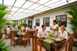 a group of people sitting at a table in a restaurant at Soma Seven Springs Resort in Munnar