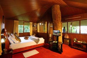 a bedroom with a bed and a tv in a room at Soma Seven Springs Resort in Munnar