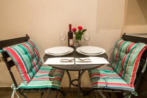 a table with two chairs with plates and wine glasses at The Golden Nest Corfu in Corfu