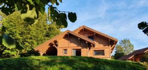 a house on top of a grassy hill at Le BÔ Chalet - Jacuzzi et Sauna - 3 chambres in Anould