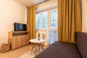 a living room with a couch and a tv and a table at Apartman Emma in Liptovský Ján