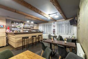a restaurant with tables and chairs and a bar at Apartman Emma in Liptovský Ján