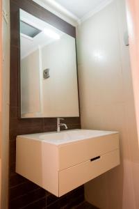 a bathroom with a white sink and a mirror at The Golden Nest Corfu in Corfu