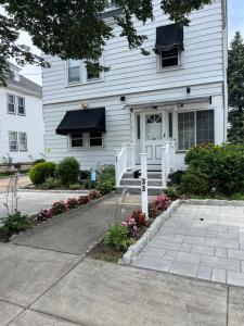 a white house with flowers in front of it at Airport room 33 in Boston