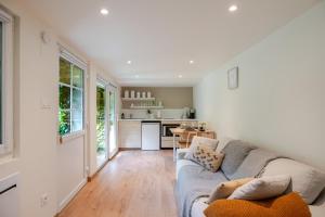 a living room with a couch and a kitchen at Cocon au fond du jardin in Souffelweyersheim