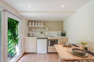 a kitchen with a wooden table and a large window at Cocon au fond du jardin in Souffelweyersheim +20 photos