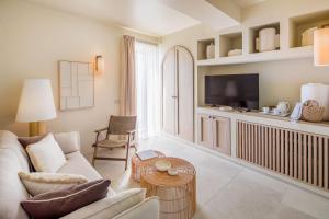 a living room with a couch and a tv at Hotel Savoia in Alassio