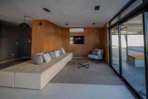 a living room with a large couch and a chair at ELLEVA STUDIOS | Studio moderno com coworking e rooftop em Sinop in Sinop