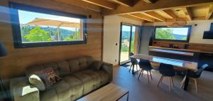 a living room with a couch and a table at Le BÔ Chalet - Jacuzzi et Sauna - 3 chambres in Anould