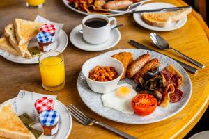 a wooden table with plates of breakfast food on it at Patterdale Hotel in Patterdale +31 photos