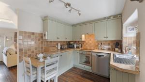 a kitchen with white cabinets and a table and chairs at 1 Bed in Hawkshead oc-lr067 in Hawkshead