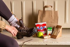 a person in a boot next to a bag and some food at Patterdale Hotel in Patterdale