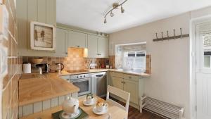 a kitchen with green cabinets and a wooden table at 1 Bed in Hawkshead oc-lr067 in Hawkshead
