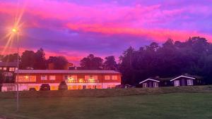 a house with a pink sunset in the sky at Terråk Gjestegård in Terråk