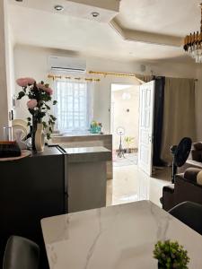 a kitchen and a living room with a table at Maison BA à Ouenzé in Brazzaville