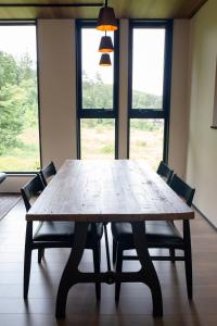 a wooden table with chairs in a room with windows at STARRY The Garden Hakuba Iwatake in Hakuba +10 photos