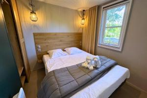 a bedroom with two stuffed animals on a bed at Camping la Clémentine in Cendras +56 photos