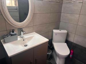 a bathroom with a sink and a toilet and a mirror at Άνεμος Home 2 in Kavála