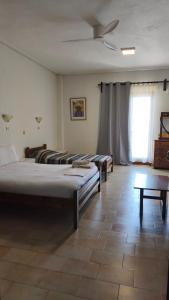 ein Zimmer mit vier Betten und einem Deckenventilator in der Unterkunft Studios Gelly's in Gythio