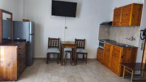 eine Küche mit Tisch, Stühlen und Kühlschrank in der Unterkunft Studios Gelly's in Gythio + 10 Fotos