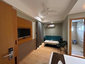 a room with a couch and a table and a television at Hashtag Inn opposite Sarusajai Stadium in Guwahati