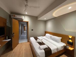 a bedroom with a large bed and a television at Hashtag Inn opposite Sarusajai Stadium in Guwahati +119 photos