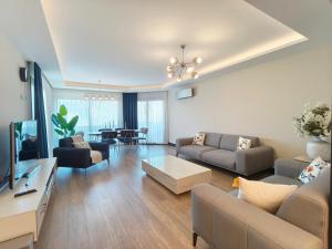 a living room with a couch and a table at Utopia Suite Residence - 4 Bedroom Apartment in Burunabat