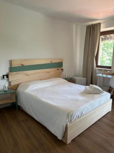 a bedroom with a large white bed and a window at Da Noi Panoramic Guest Stay Camera Orizzonte in Cuorgnè