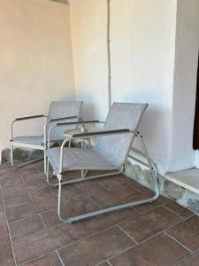 two chairs and a table on a tiled floor at Da Noi Panoramic Guest Stay Camera Orizzonte in Cuorgnè