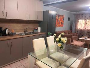 a kitchen with a glass table and a living room at Άνεμος Home 2 in Kavála