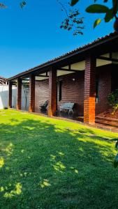 a brick house with a green lawn in front of it at Pousada Brisa do Oceano - Cumbuco in Cumbuco