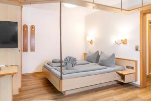 a couch in a living room with a tv at Hotel Restaurant Fallerhof in Bad Krozingen