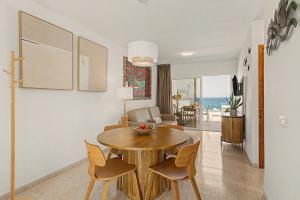 a dining room and living room with a table and chairs at Callao Beach 6 in Arrieta