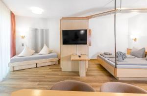 a hotel room with two beds and a flat screen tv at Hotel Restaurant Fallerhof in Bad Krozingen